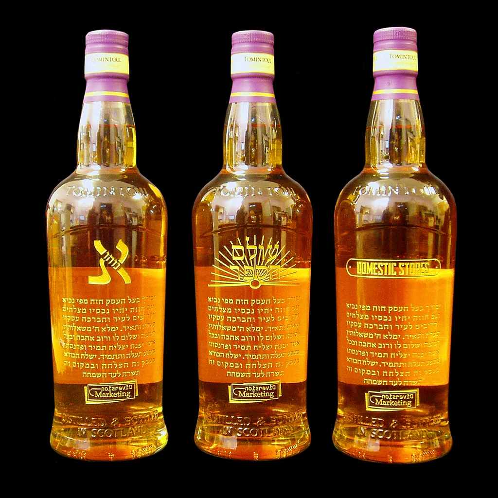 Bespoke engraved whisky bottles with detailed lettering and graphics