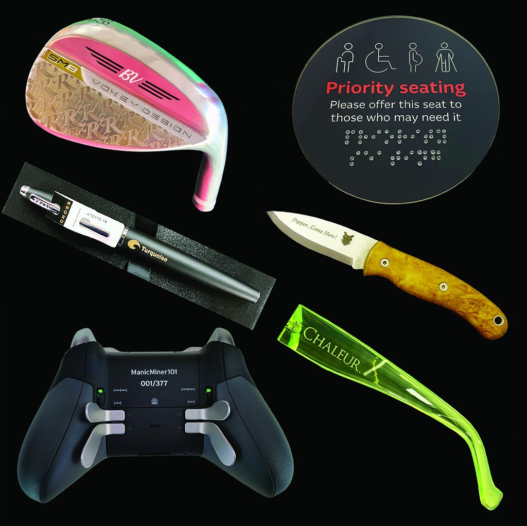 Specialist engraving examples including golf club, Braille sign, pens, knife, game controller and spectacle frame by Furnells